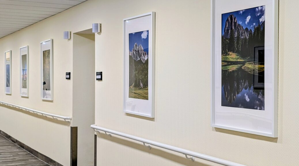 Gestalteter Flur im EKH Schwarzenberg mit thematisch angeordneten Landschaftsbildern in weißen Rahmen